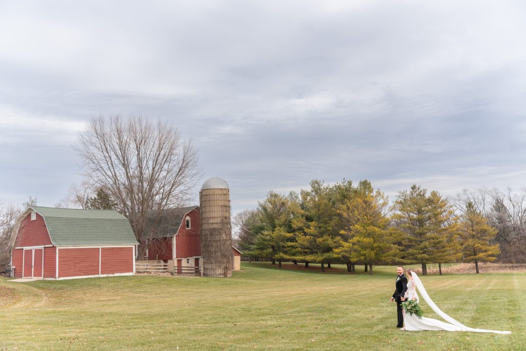 bride and groom walk across a field The Pavilion at Orchard Ridge Farms